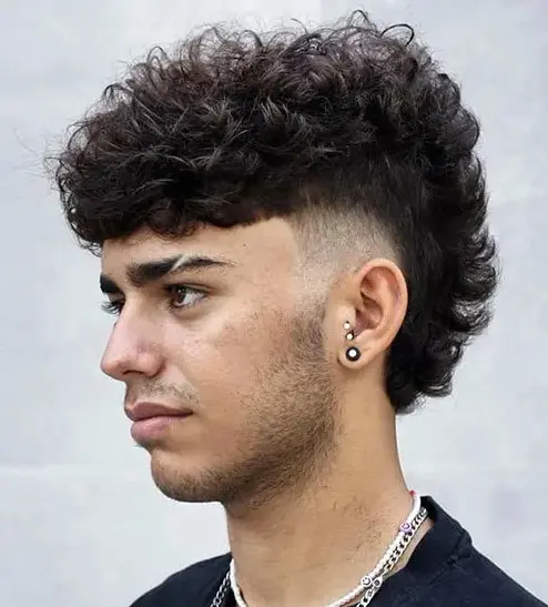 Bold Rock Style Curly Mohawk With Fade For Volume.