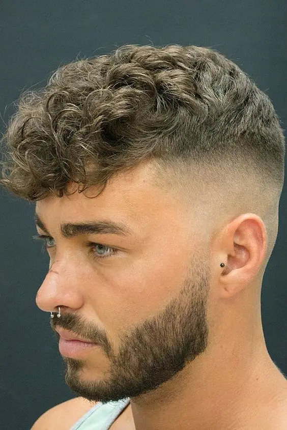 Modern Gent Style With Long Curly Top, High Undercut Fade, Stylish Beard.