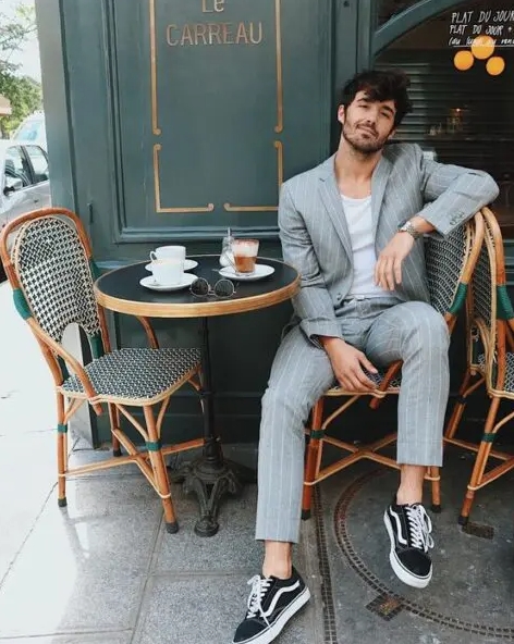 A grey linen thin stripe suit a white t shirt and black sneakers for a relaxed and informal summer wedding