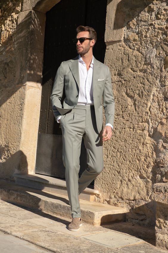 A grey suit a white button down taupe moccasins to look stylish at a spring or summer wedding