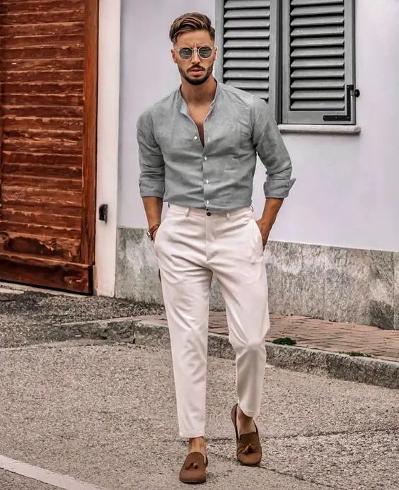 A hot weather wedding guest look with a linen shirt white trousers brown moccasins is a stylish idea