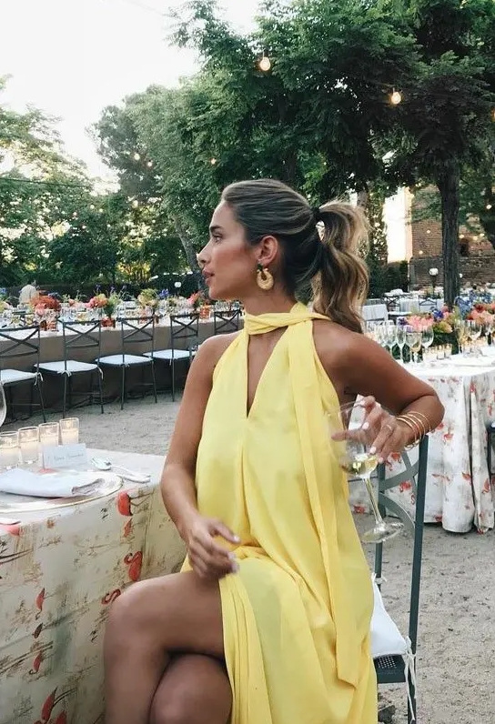 A lovely and flowy yellow dress with a matching scarf and statement earrings is a great idea for a summer bridal shower