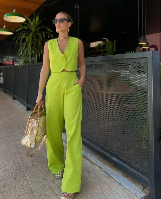 A neon green suit with a vest and pants sheer shoes and a metallic bag plus gold accessories are great for the summer