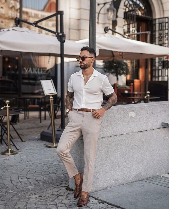 A relaxed guest outfit with a white button down grey pants brown moccasins and a brown belt