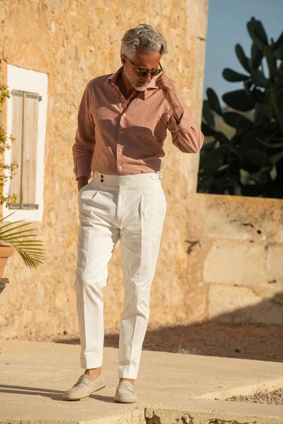 A relaxed summer wedding look with a rust linen button down white pants grey loafers is chic and stylish