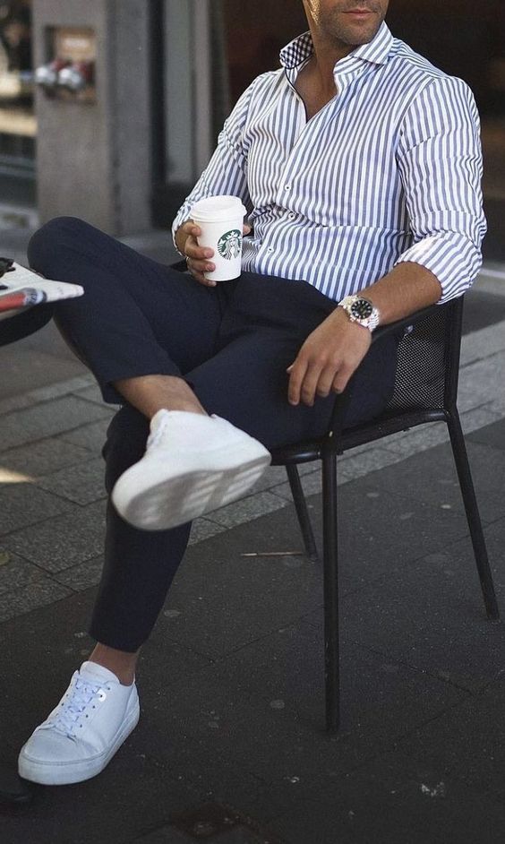 A relaxed summer wedding look with a striped button down navy pants white sneakers is a cool idea for the summer