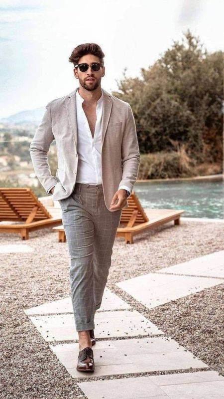 An elegant summer outfit with a white shirt grey windowpane pants a tan linen blazer brown shoes