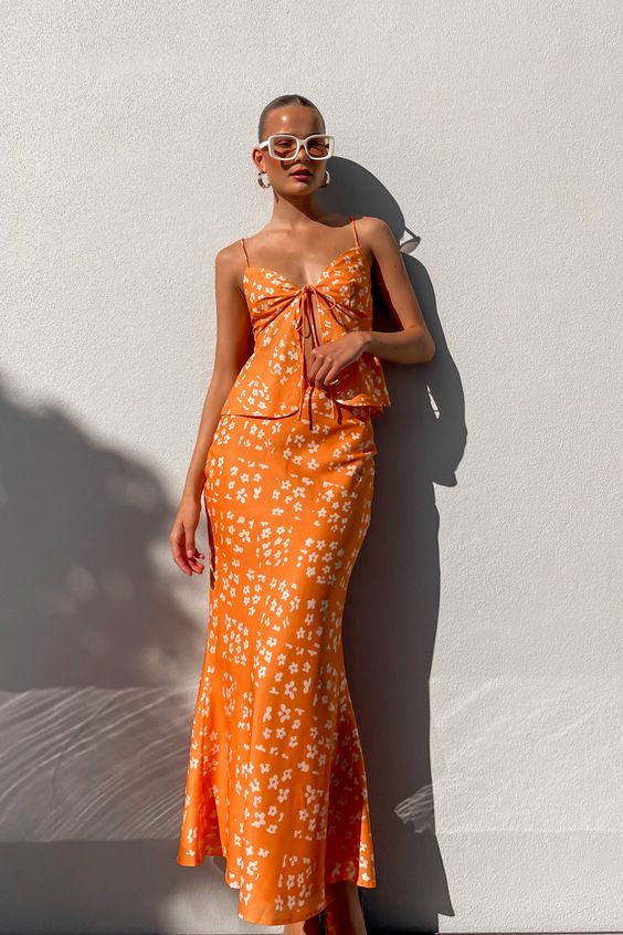 This bold two piece combo of a spaghetti strap top and maxi skirt in orange and with a floral print will be great for a bridal shower
