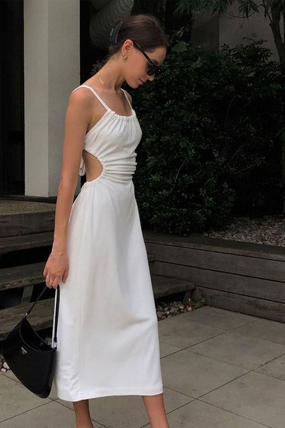 a fab minimalist bride to be look with a white dress with side cutouts and a small black bag is ultimate