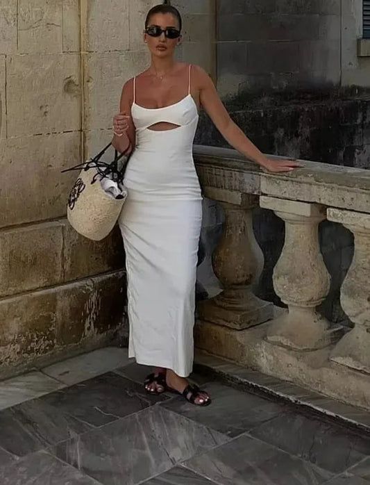 a hot weather look with a spaghetti strap maxi dress with a cutout a straw bag and brown sliders