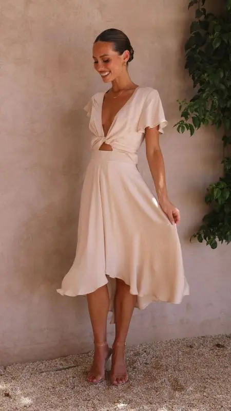 a pretty midi gown with a deep neckline and a cutout short sleeves and cleat shoes is a flirty idea for a bridal shower