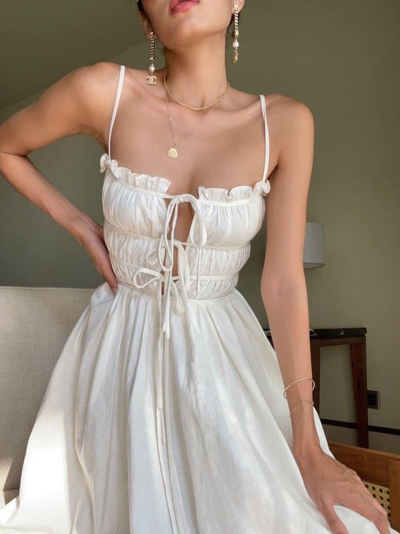 a pretty spaghetti strap dress with a bodice with bows and some chic jewelry are a charming combo